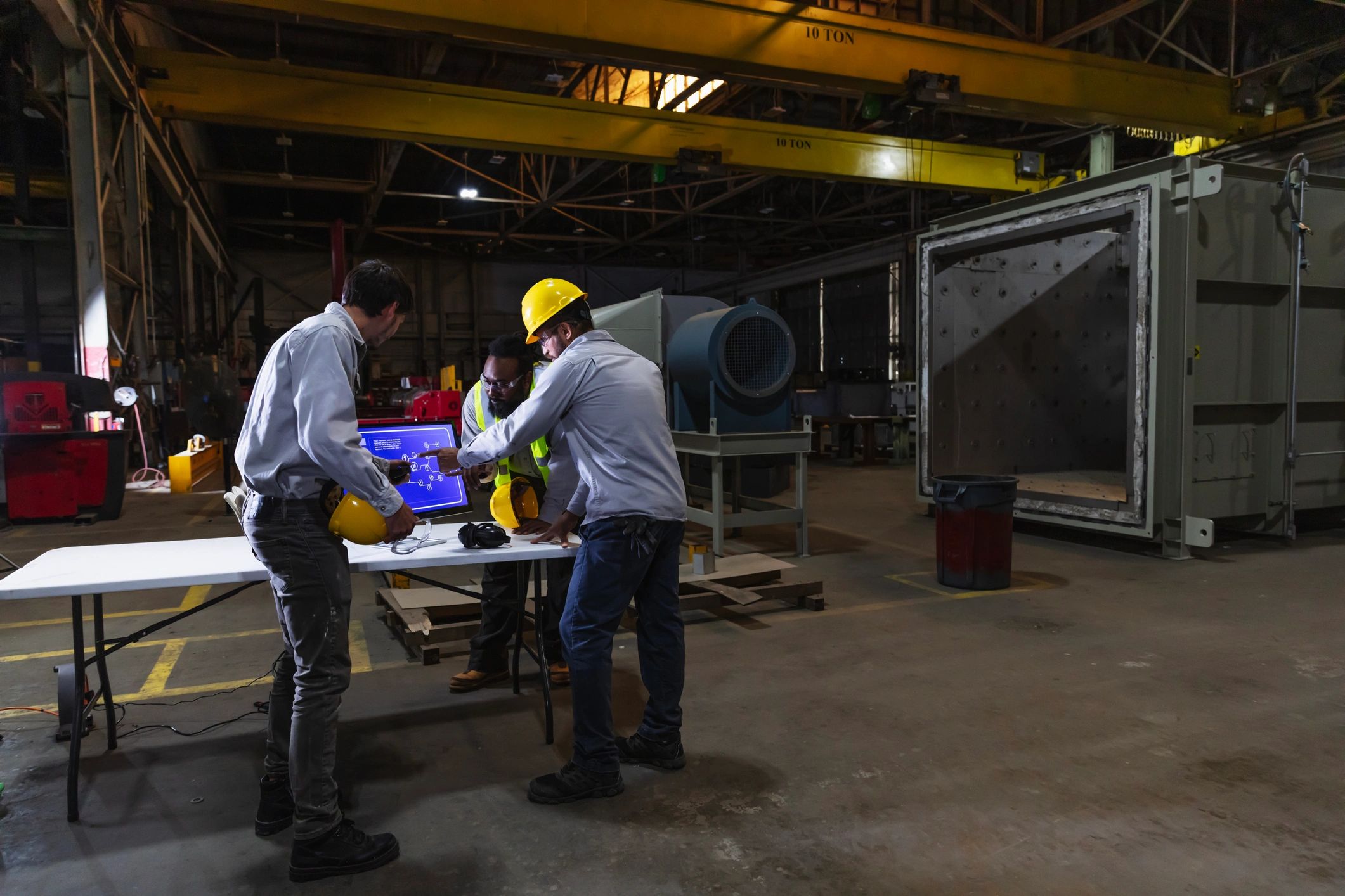 Equipo de ingeniería eléctrica revisando información técnica en entorno industrial